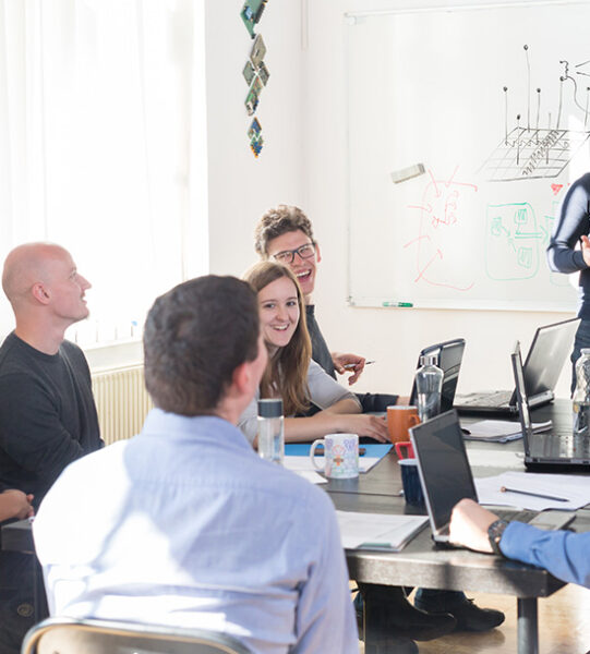 Relaxed informal IT business startup company meeting. Team leader discussing and brainstorming new approaches and ideas with colleagues. Startup business and entrepreneurship concept.